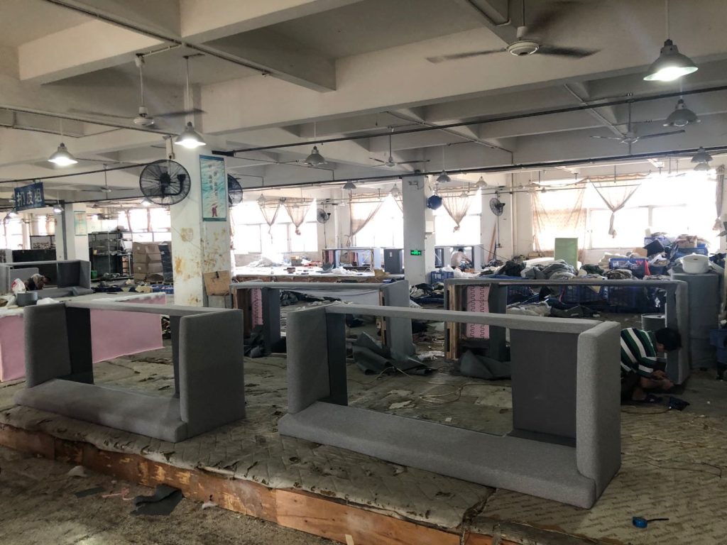 Production floor with upholstered frames staged for inspection