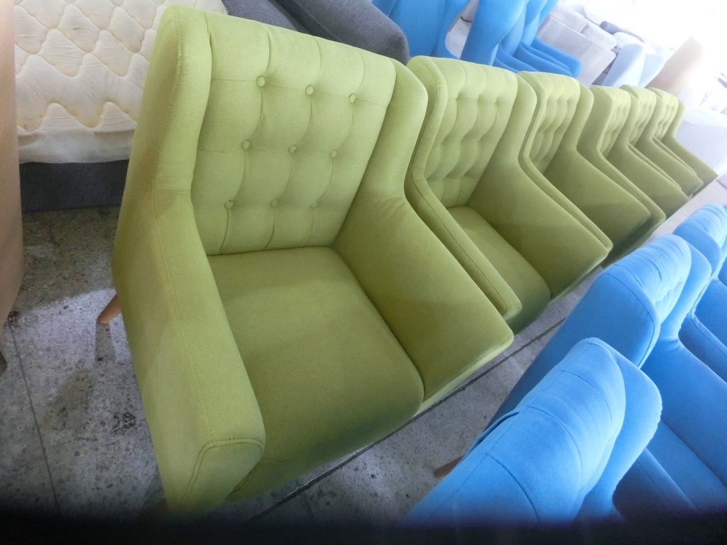 Green button-tufted accent chairs for hotel interiors