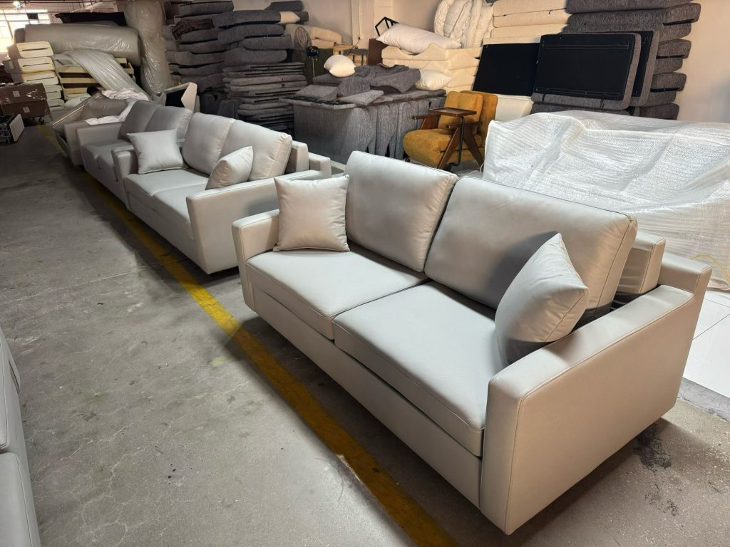 Light-grey sofa beds grouped in the workshop before project review