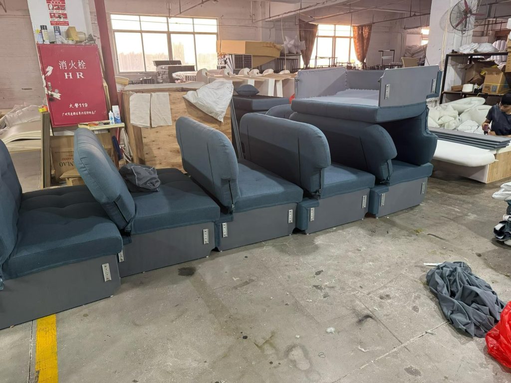 Several sofa beds grouped with workshop stock in the background